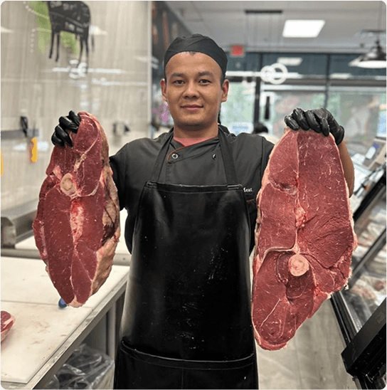 Adal Meat Market owner holding cuts of meat